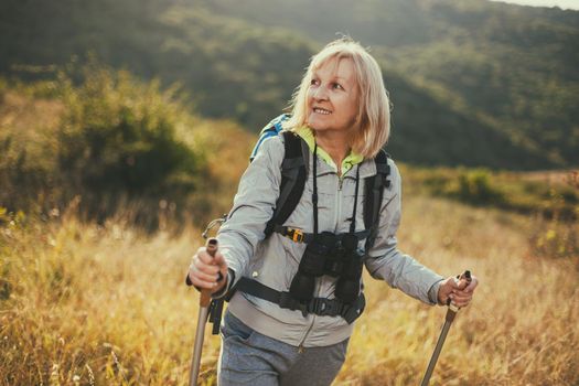 Senior woman is hiking in mountain. Active retirement.