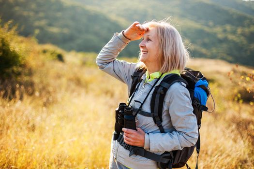 Senior woman is hiking in mountain. Active retirement.