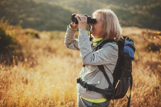 Senior woman is hiking in mountain. Active retirement.