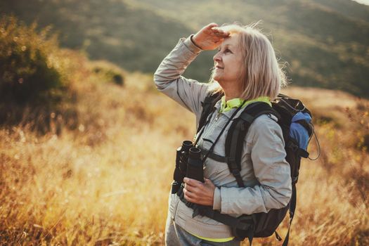 Senior woman is hiking in mountain. Active retirement.