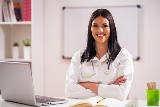 Portrait of young happy doctor in her office.