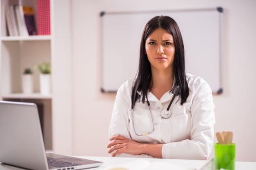 Portrait of angry doctor in her office.