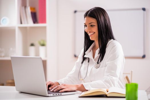 Portrait of young happy doctor in her office.