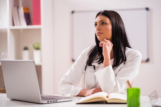 Portrait of young pensive doctor in her office.