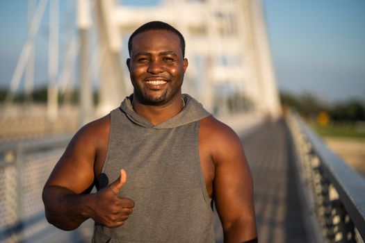 Portrait of young cheerful african-american man in sports clothing who is looking at camera and smiling.