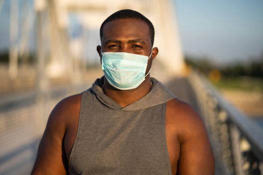 Portrait of young african-american man with protective mask on his face. Corona virus pandemic responsible behavior.