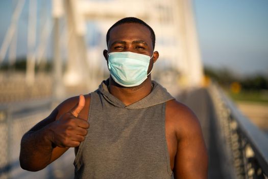 Portrait of young african-american man with protective mask on his face. Corona virus pandemic responsible behavior.
