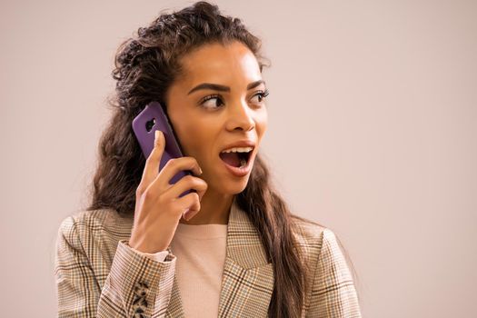 Studio shot portrait of beautiful african-american ethnicity businesswoman talking on phone.