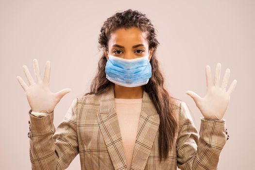 Studio shot portrait of beautiful african-american ethnicity businesswoman wearing protective mask.