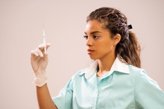 Portrait of young nurse who is holding syringe.