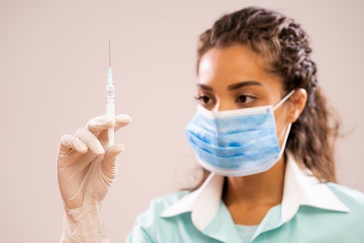 Portrait of young nurse who is holding syringe.