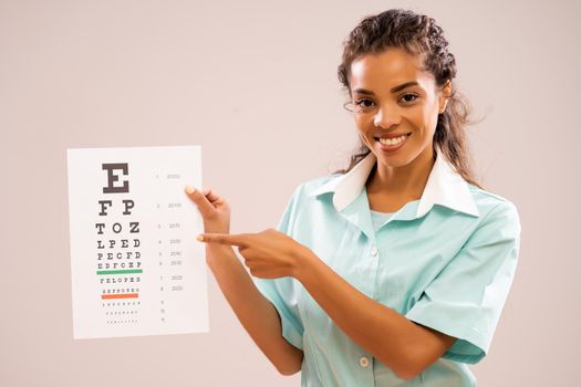 Portrait of young nurse who is holding eye examination test.
