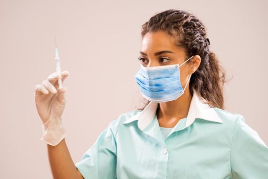 Portrait of young nurse who is holding syringe.