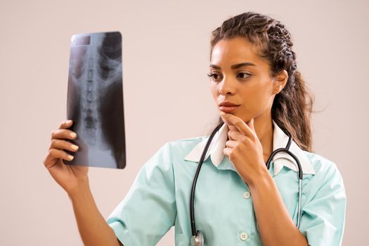 Portrait of young nurse who is looking at x-ray image.