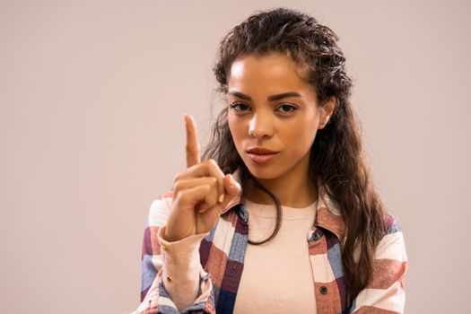 Studio shot portrait of beautiful african-american ethnicity woman who threatens.