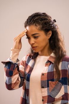 Studio shot portrait of beautiful african-american ethnicity woman who is worried and pensive.