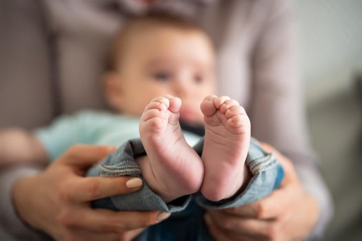 Close up image of baby feet. Mother is holding feet of her baby boy.