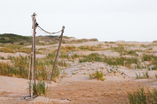 Neglected beach volleyball net on coastal sand dunes, Mossel Bay, South Africa