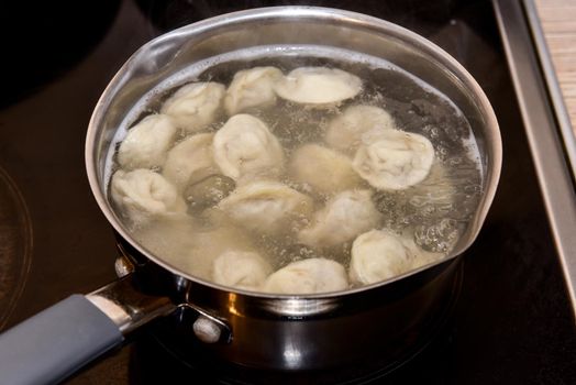 Russian Dumplings in boiling water. Meat dumplings are boiled in a pot of boiling water.