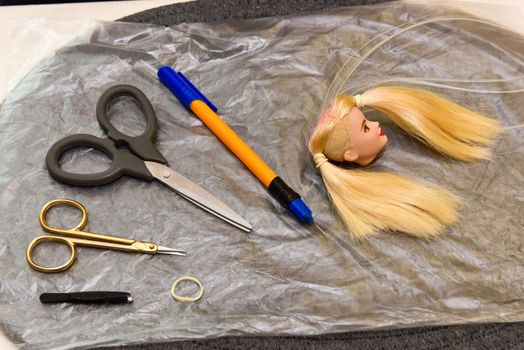 scissors and homemade tool on the table, how to make hair for a doll, hobby concept.