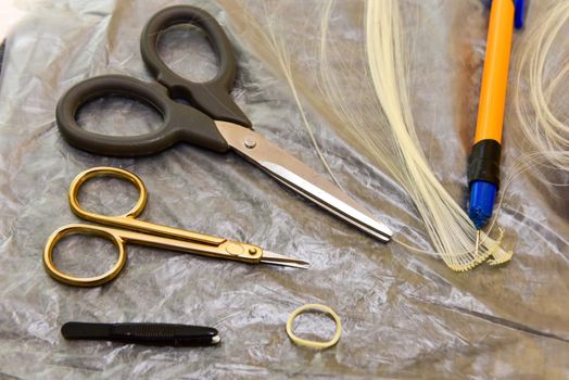 scissors and homemade tool on the table, how to make hair for a doll, hobby concept.