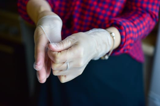 woman takes rubber gloves off her hands.