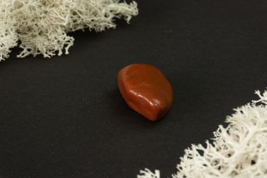 Red Jasper from Brazil. Natural mineral stone on black background. Mineralogy, geology, magic of stones, semi-precious stones and samples of minerals. Close-up macro photo.