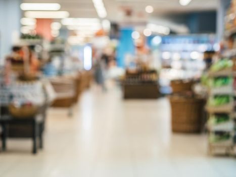 Abstract blurred supermarket aisle with colorful shelves and unrecognizable customers as background