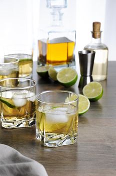 Alcohol cocktail with brandy, whiskey or rum with Ginger Ale, lime and ice in glasses  