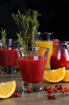 Freshly prepared cranberry fruit-drink with orange juice and a sprig of rosemary