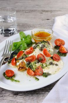 grilled chicken breast  topped with melted mozzarella cheese, basil  pesto, tomato  and caper