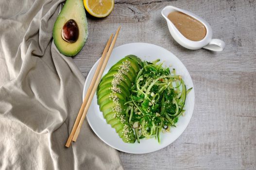 Chukka salad, cucumber noodles with avocado and peanut brown sauce in sauce boat