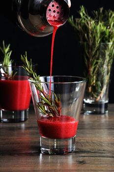 Freshly made cranberry juice with a sprig of rosemary