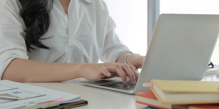 Young Asian Businesswoman on laptop computer in office.