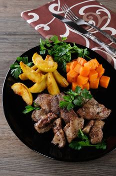 Fried chicken liver with vegetable garnish, baked pumpkin and apple. 
