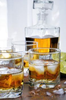 Alcohol cocktail with brandy, whiskey or rum with Ginger Ale, lime and ice in glasses  