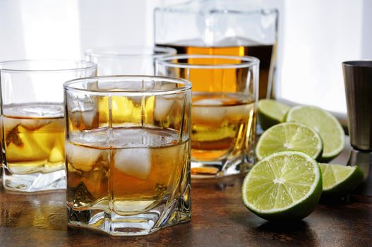 Alcohol cocktail with brandy, whiskey or rum with Ginger Ale, lime and ice in glasses  