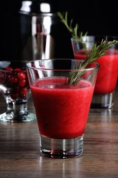 Freshly made cranberry juice with a sprig of rosemary