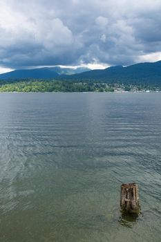 Beautiful view over ocean harbor and mountain on cloudy day in Vancouver, Canada.