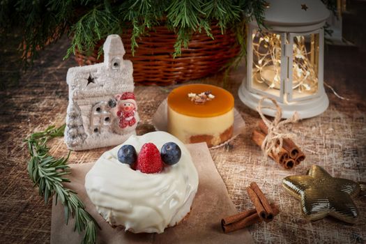 A cake decorated with blackberries and raspberries on a New Years table with a flashlight and a spruce branch. Christmas