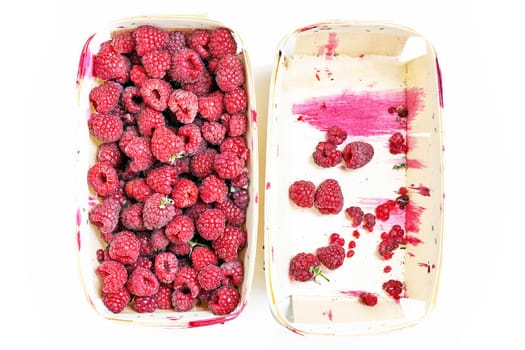 Container with different amounts of fresh red raspberries. Top view close up
