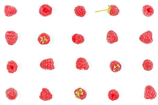 Ripe red raspberries are laid out in lines on a white background in various poses. View from above