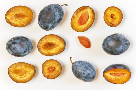 Ripe dark plums in various forms. Prunes on a light background, top view