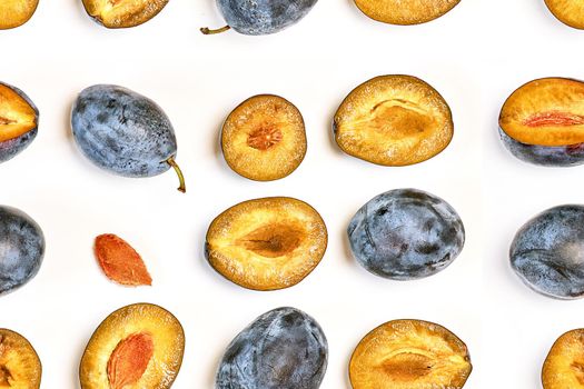 Ripe dark plums in various forms. Prune pattern on a light background, top view