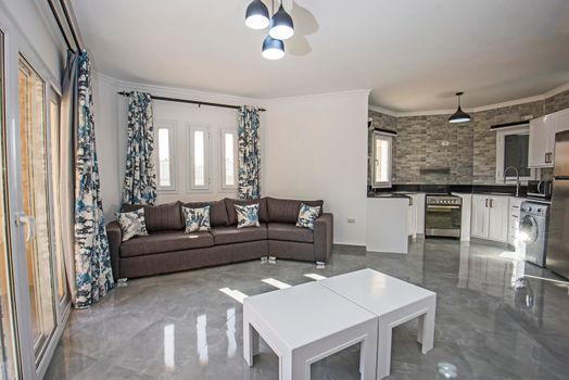 Living room lounge area in luxury apartment show home showing interior design decor furnishing with open plan kitchen