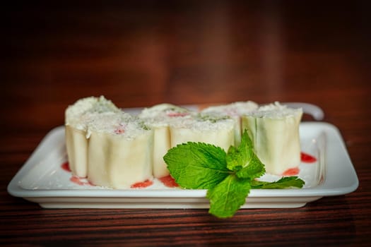 White dish with japanese fruit dessert minari and green mint leaf on wooden table background