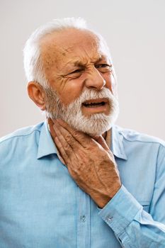 Portrait of senior man who is having pain in neck glands.