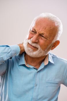 Portrait of senior man who is having pain in neck.