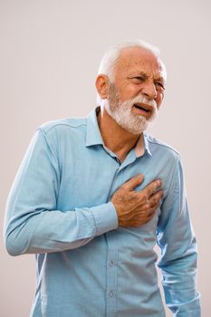 Portrait of senior man who is having pain in his chest.