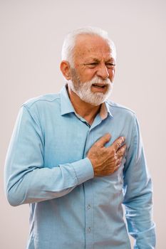Portrait of senior man who is having pain in his chest.